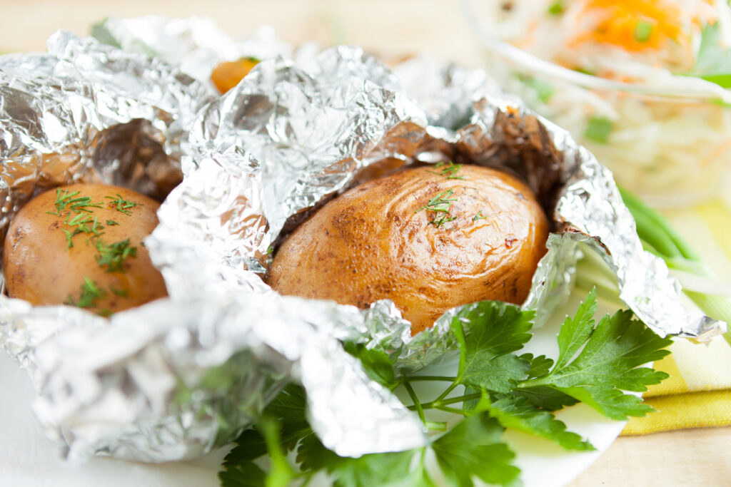 Baked potatoes wrapped in aluminum foil.