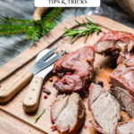 Pinterest pin for cooking wild game. Image of cooked wild game on a wooden cutting board.