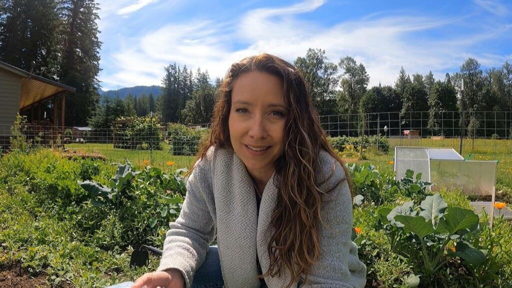 A woman crouched down in her garden.