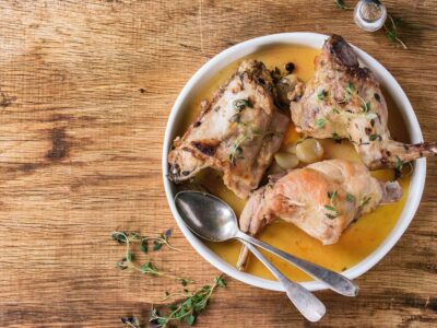 A plate with roasted rabbit and broth.