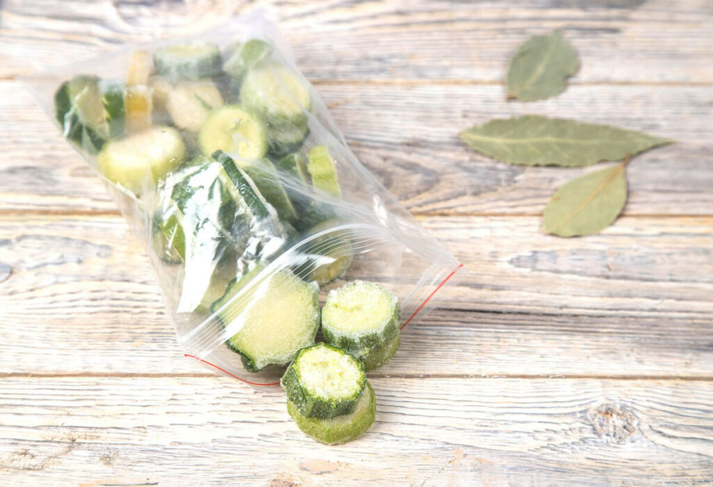 Frozen zucchini rounds in a plastic ziptop bag.