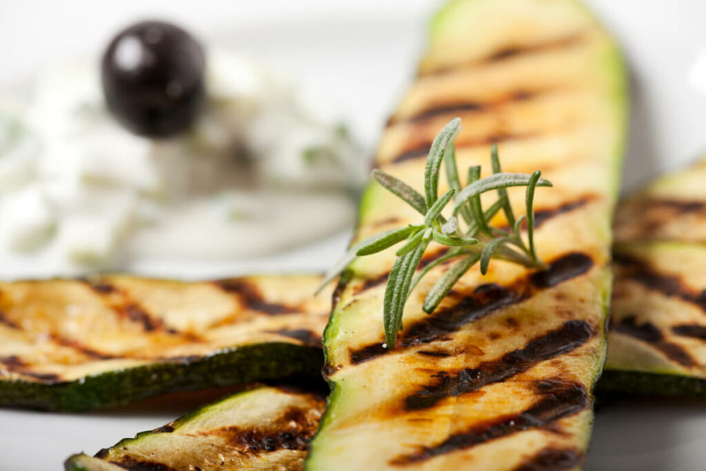 Grilled zucchini on a white plate.