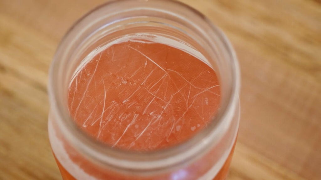 Kahm yeast on the surface of a ferment in a mason jar.