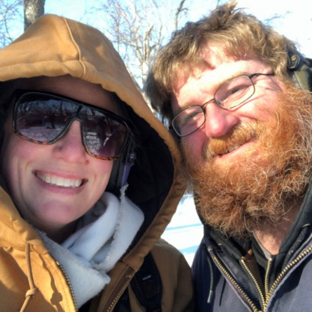 A husband and wife dressed in winter coats.