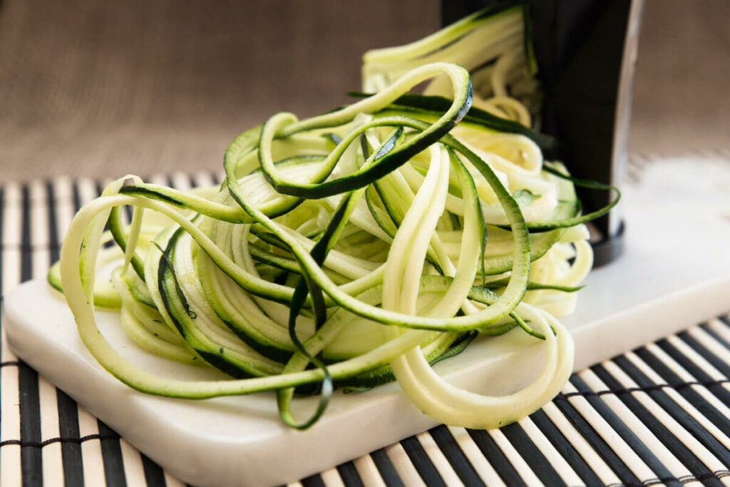 Zucchini noodles (zoodles) on a cutting board.