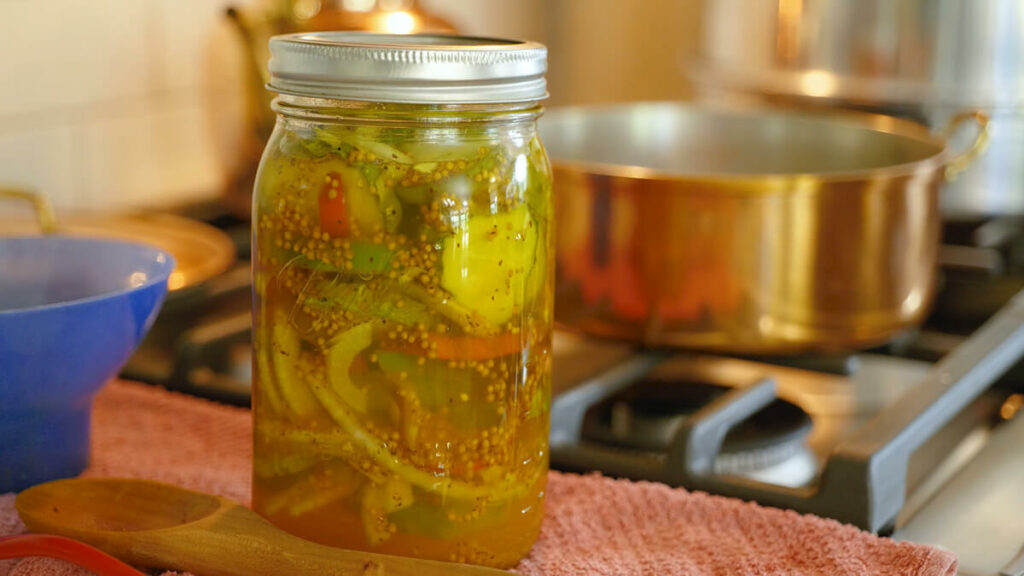 Bread and butter pickles sitting on the counter in a jar.