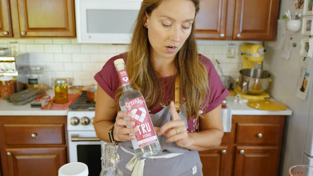 A woman holding a bottle of organic vodka.