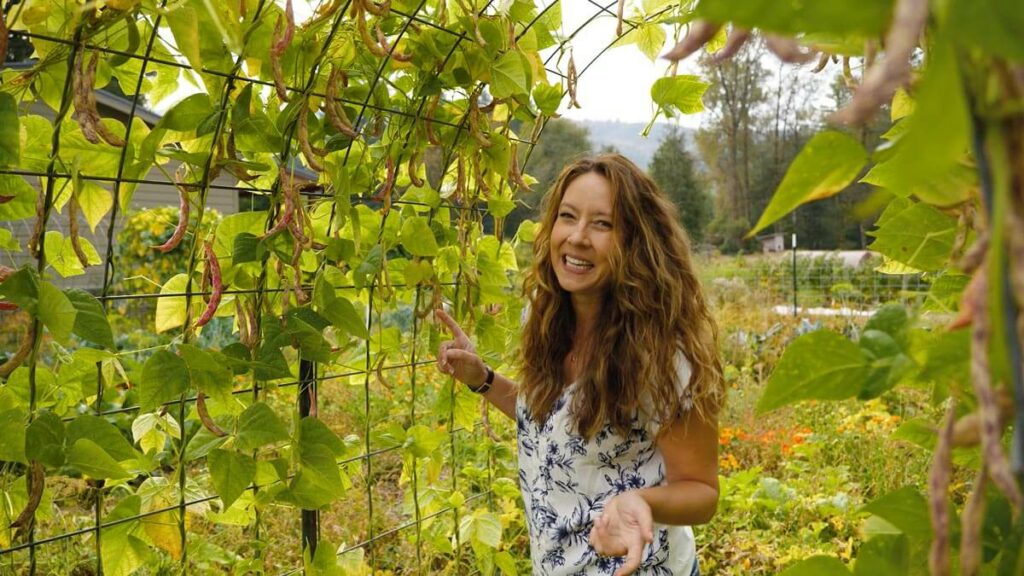 A woman standing in a bean tunnel.