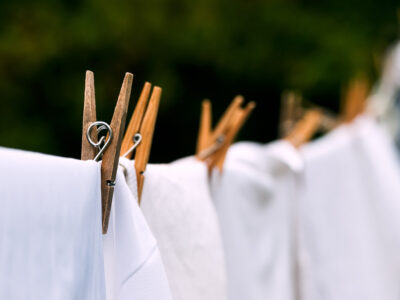 A clothesline with white sheets and clothespins.