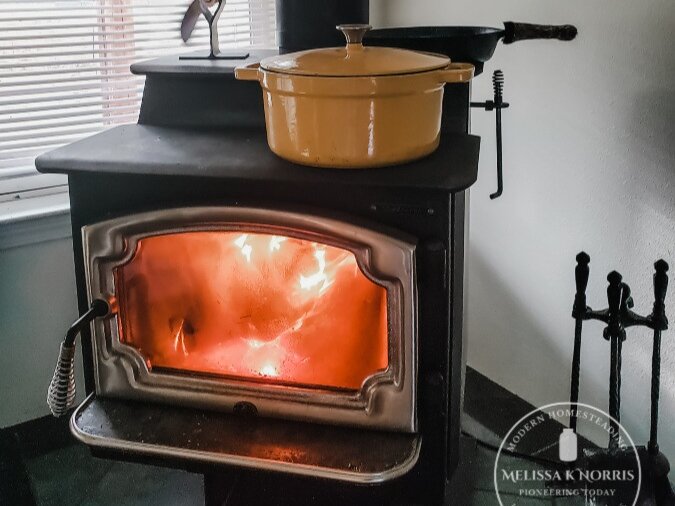 Picture of a wood stove with a pot on top.