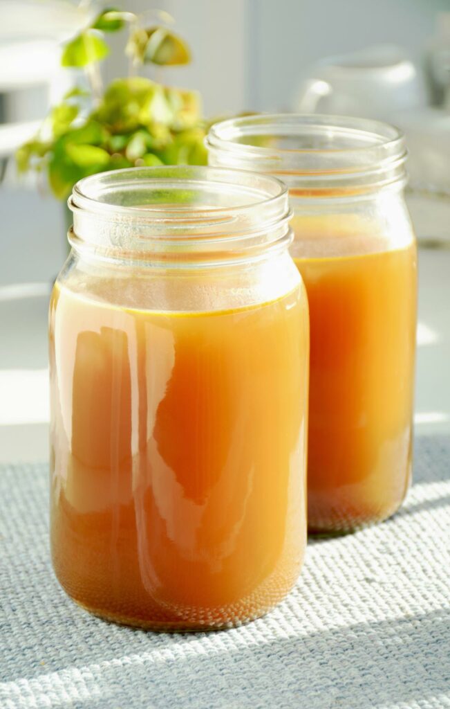 Two Mason jars of bone broth on a towel.