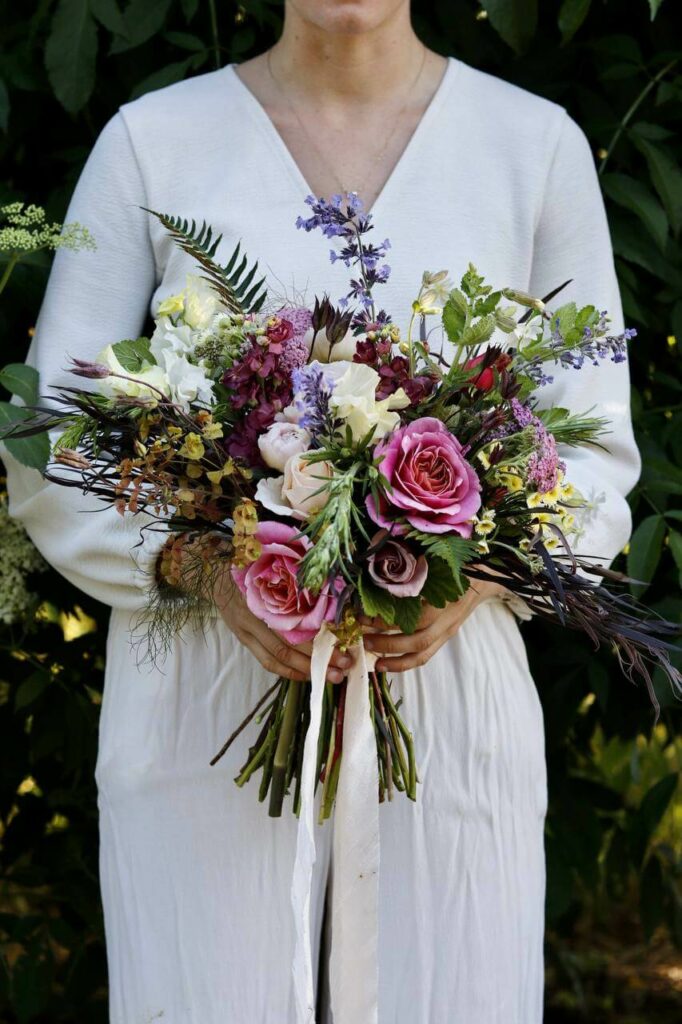 A woman holding a beautiful fresh flower bouquet.