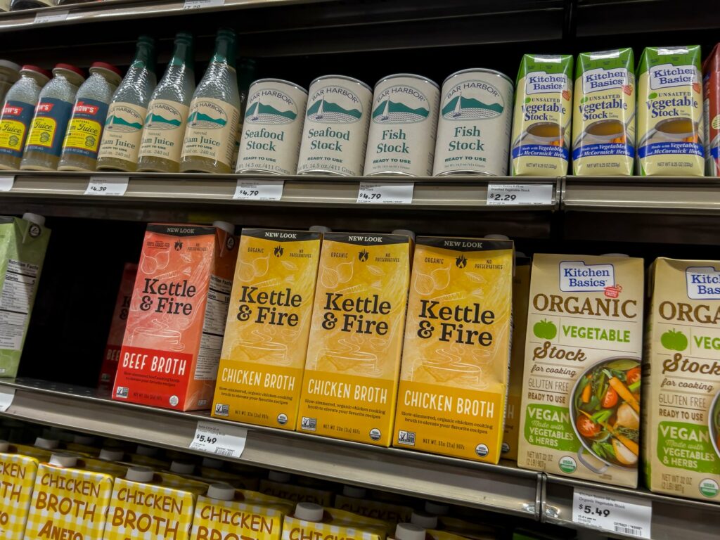 Grocery store shelves lined with various broths.