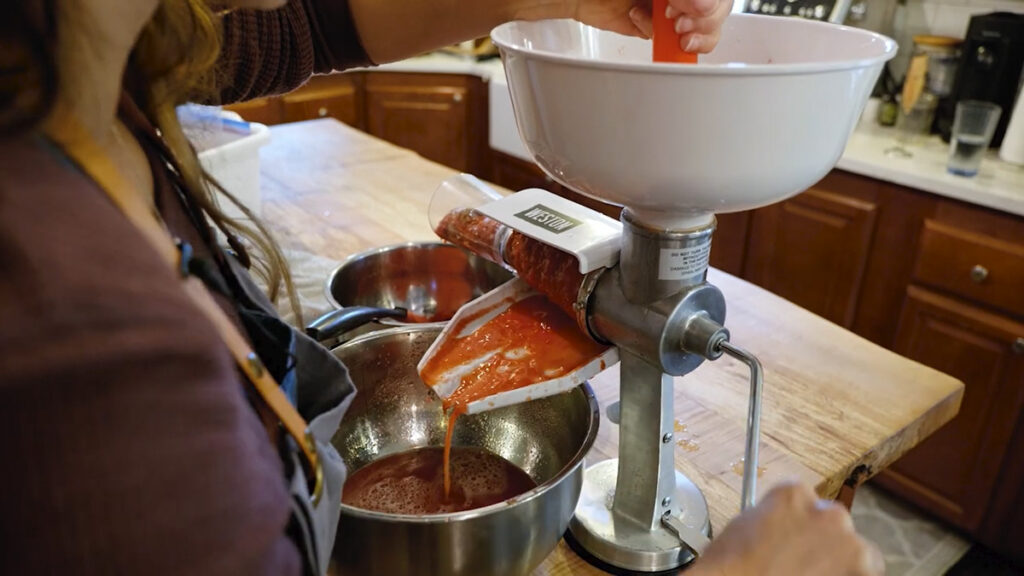 A Weston tomato press pressing tomatoes.