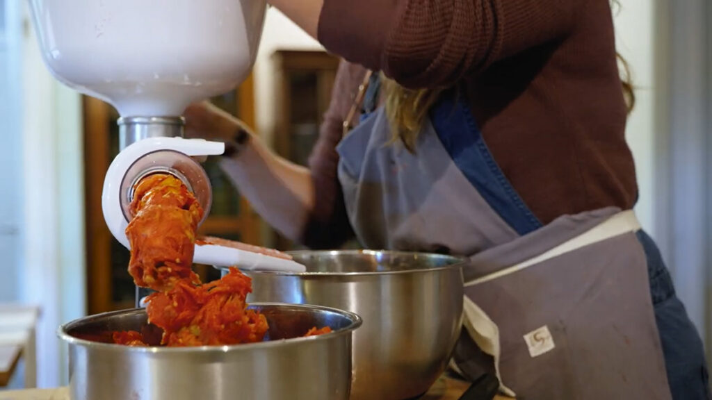 A woman spinning a tomato press.