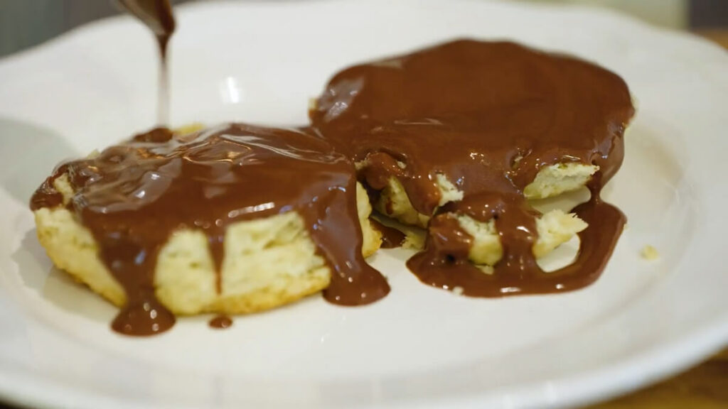 Up close image of a biscuit covered with chocolate gravy.