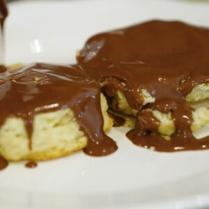 Up close image of a biscuit covered with chocolate gravy.