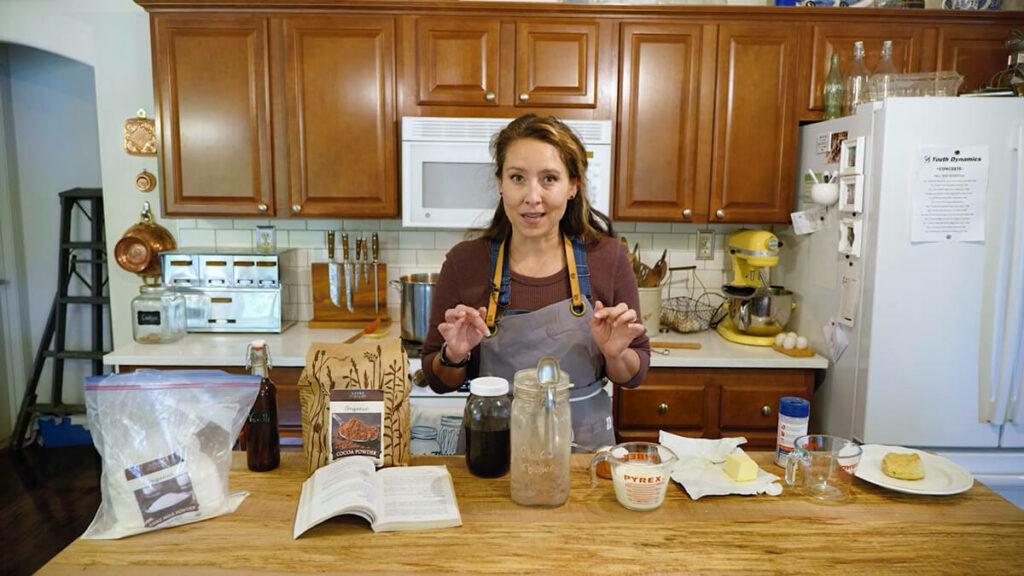 A woman in the kitchen with ingredients for chocolate gravy in front of her.