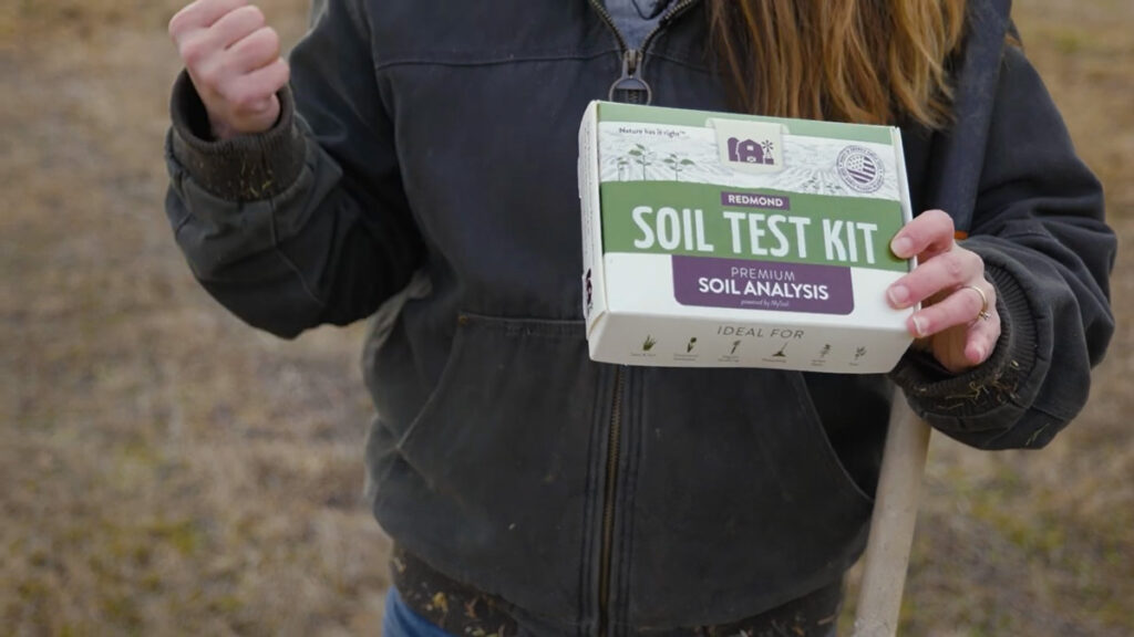 A woman holding a Redmond Soil Test Kit box.