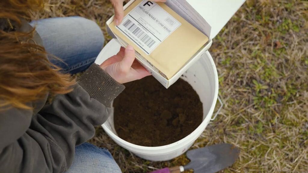 A bucket of soil and a DIY soil test kit.