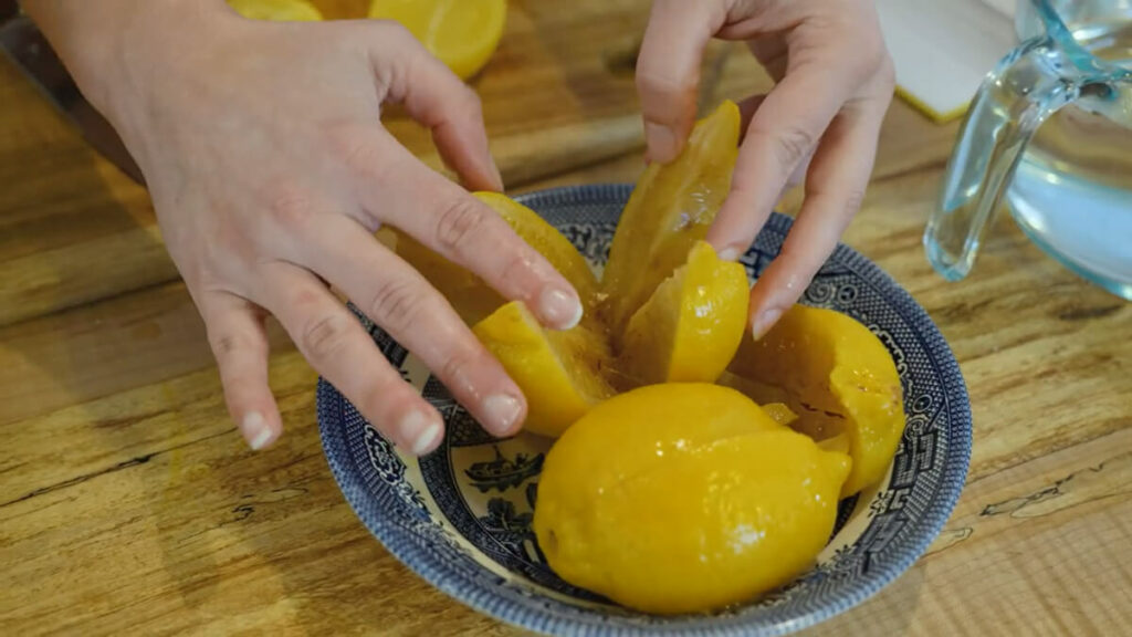 Fermented lemons sliced open in a bowl.