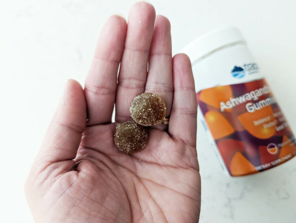 Ashwagandha gummies, adaptogen herbs in a woman's hand.