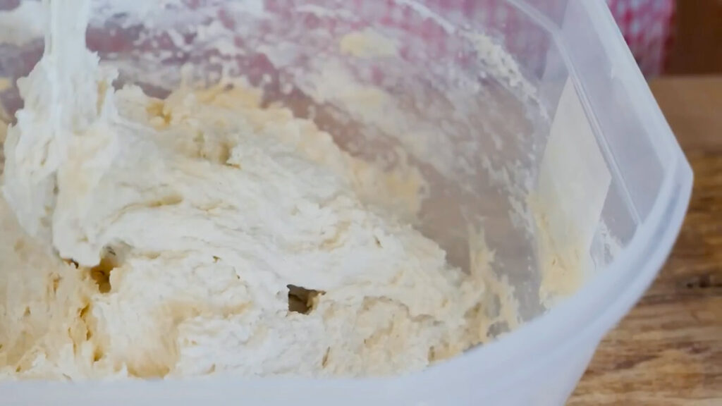 A dough whisk mixing flour, water, yeast, vinegar, and salt to make a shaggy dough.