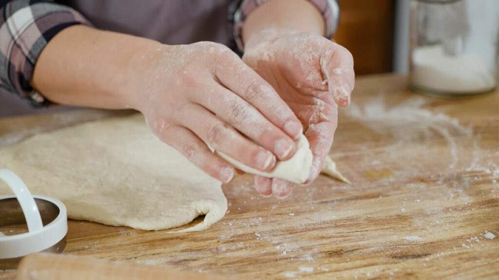 A woman's hands folding bao buns.