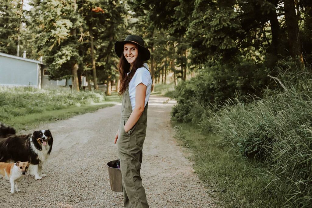 Image of a woman walking down a path holding a bucket for raw milk.