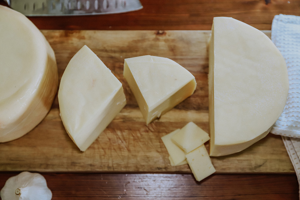 Vertical shot of cheese on a cutting board.