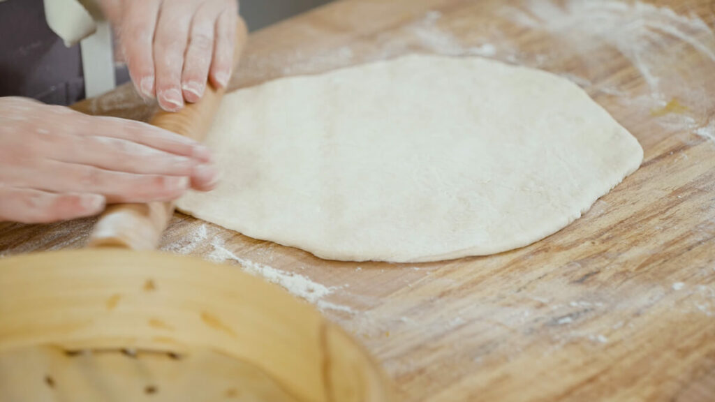 Bao bun dough rolled out with a rolling pin.