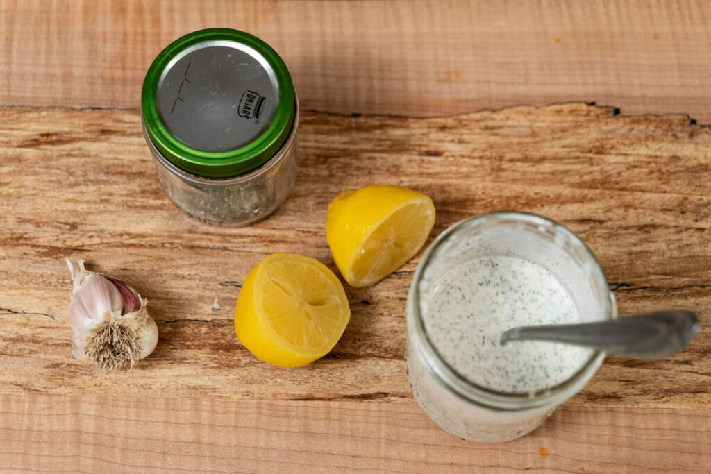 Buttermilk ranch dressing in a Mason jar next to ingredients.
