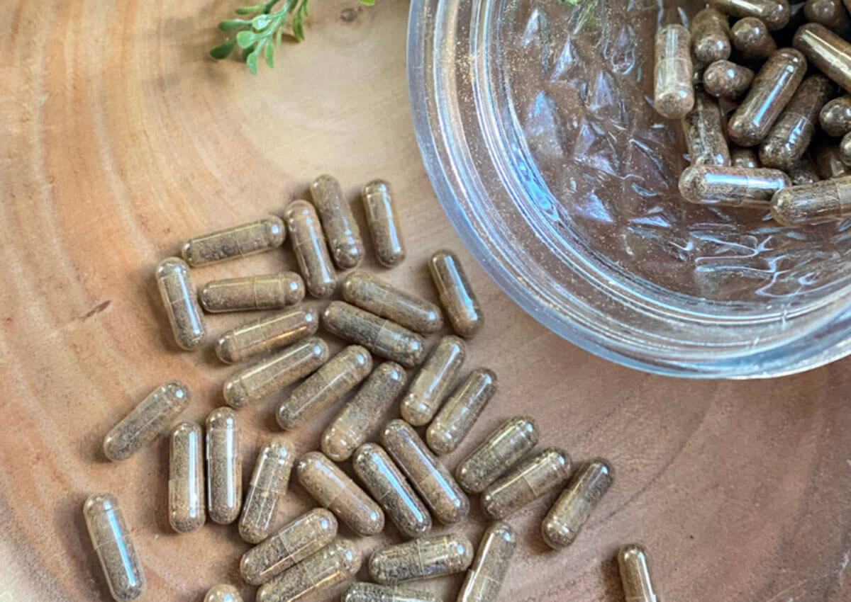 Beef liver capsules on a counter and in a jar.