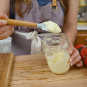 Homemade mayonnaise recipe in a jar on a spatula.