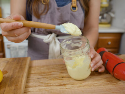 Homemade mayonnaise recipe in a jar on a spatula.