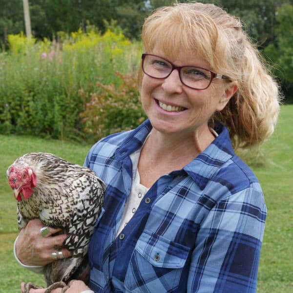 Image of a woman holding a chicken.