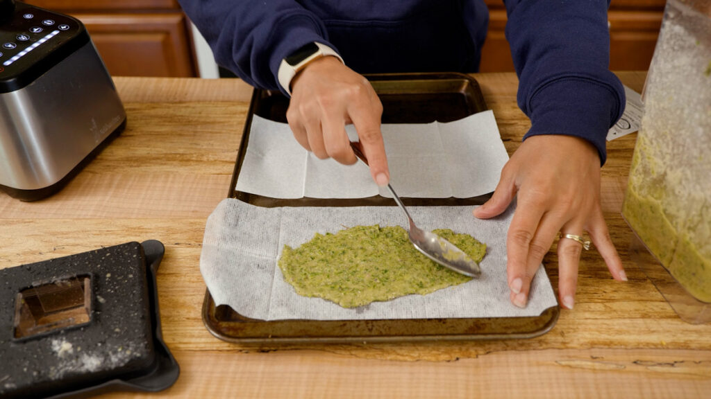 A woman spreading comfrey poultice onto gauze sheets.