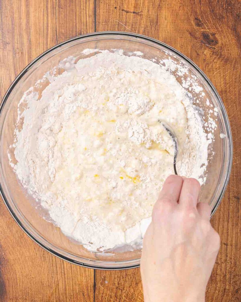 A fork whisking together wet and dry pancake ingredients.