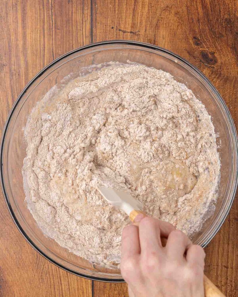 A spatula folding together wet and dry muffin ingredients.