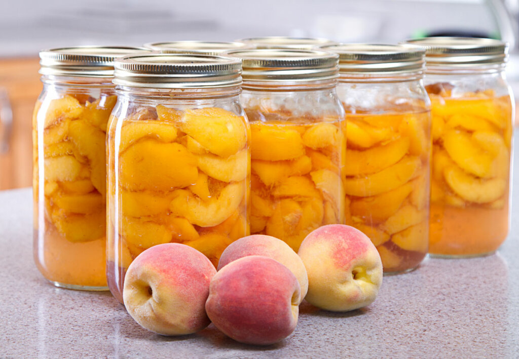 Quart jars filled with canned peaches.