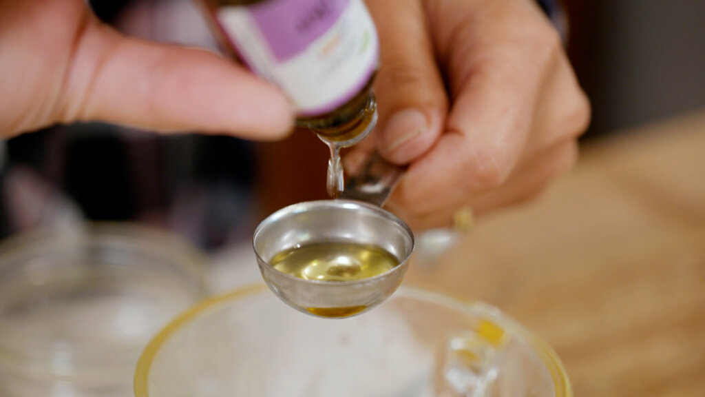 Essential oils being measured into a Tablespoon.
