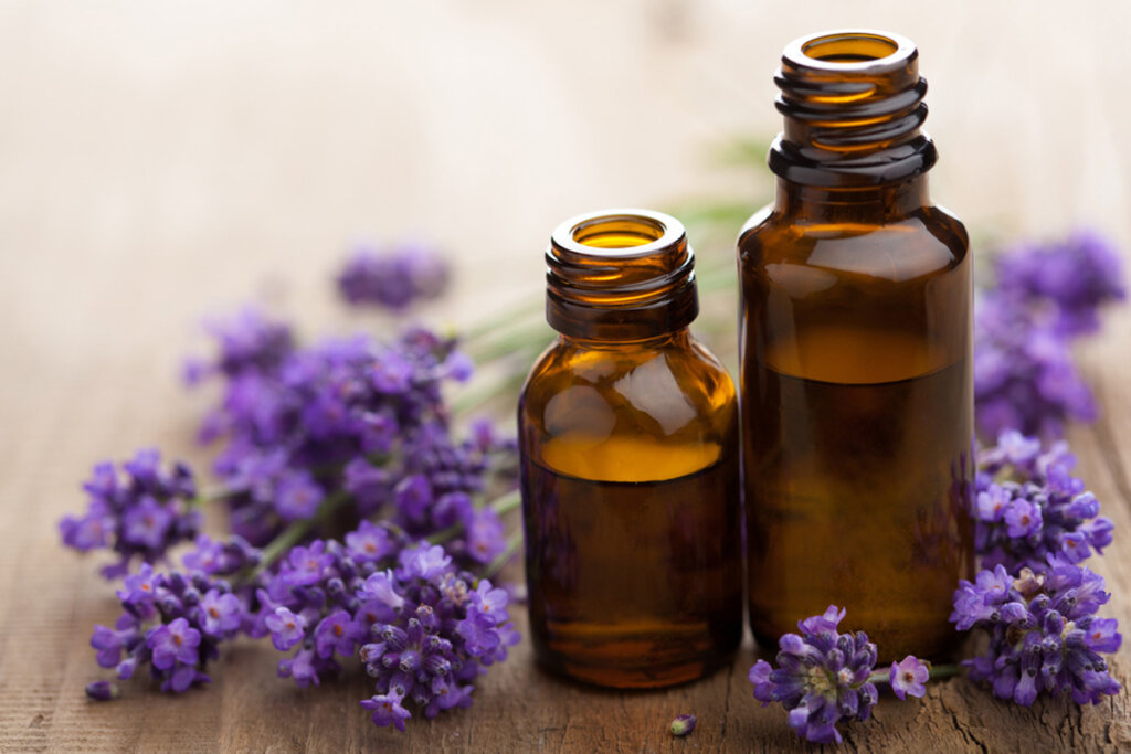 Two bottles of essential oils with fresh lavender.