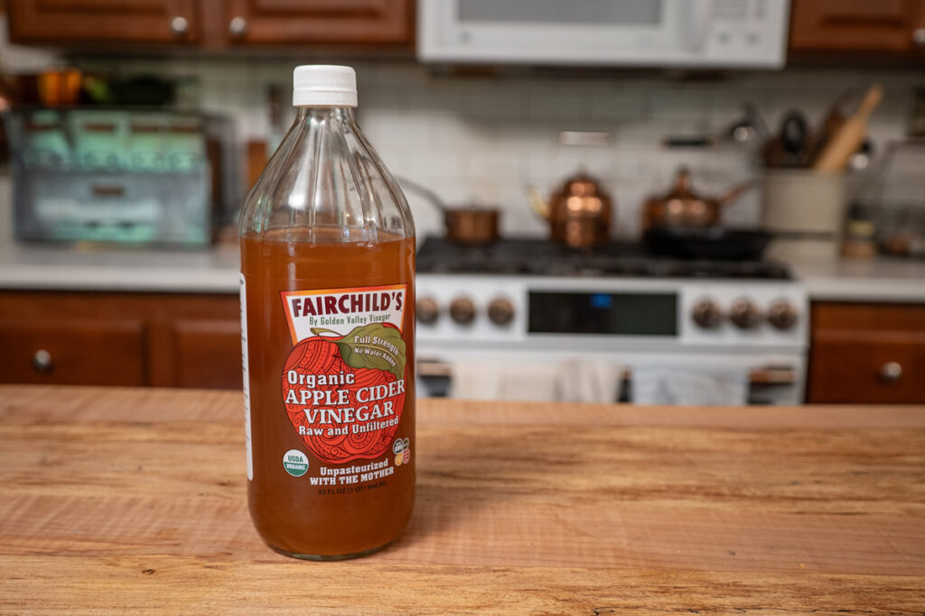 A bottle of Fairchild's apple cider vinegar on a kitchen counter.