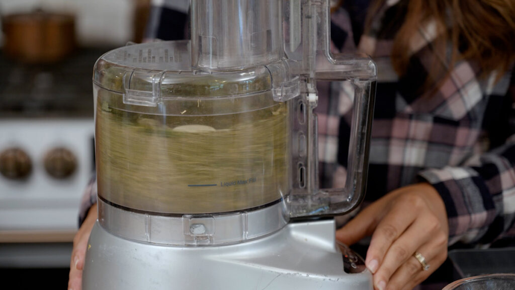 Herbs being powdered in a food processor.