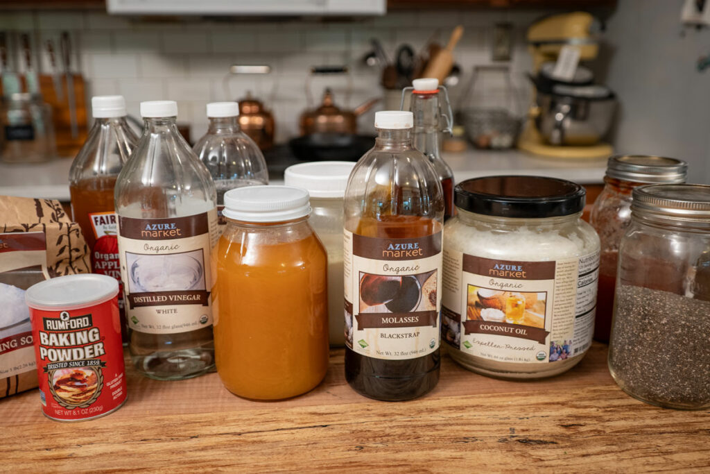 Baking ingredients in containers on a wooden kitchen island.