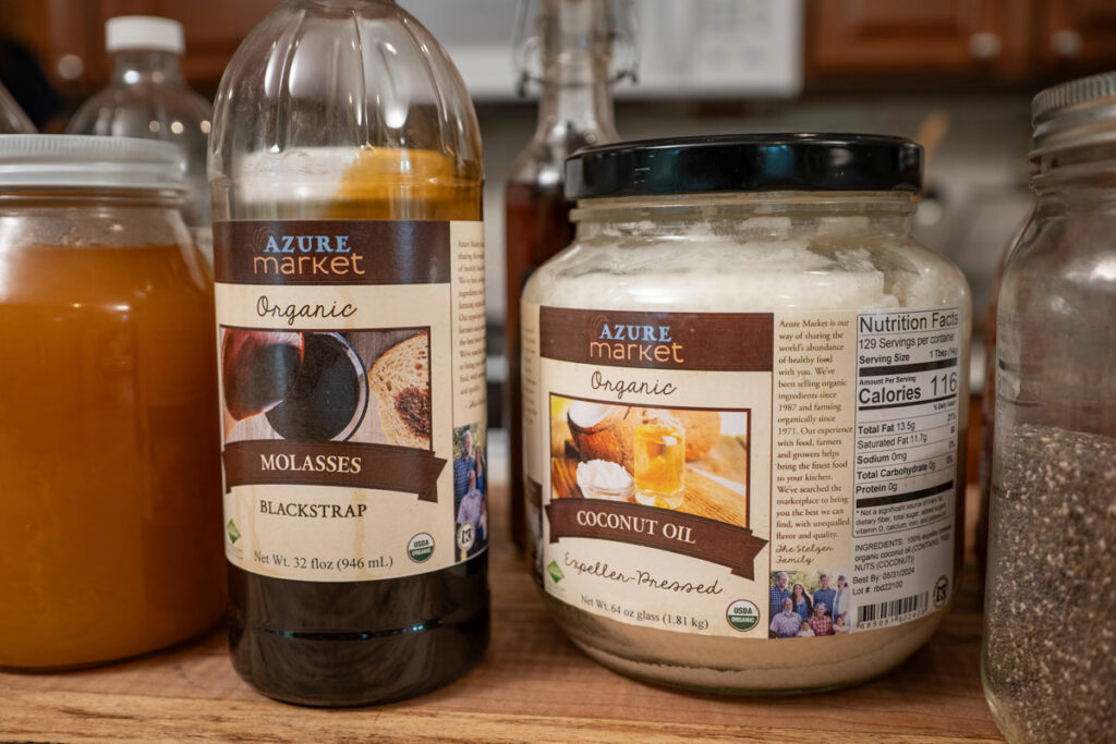 Baking ingredients in containers on a wooden kitchen island.