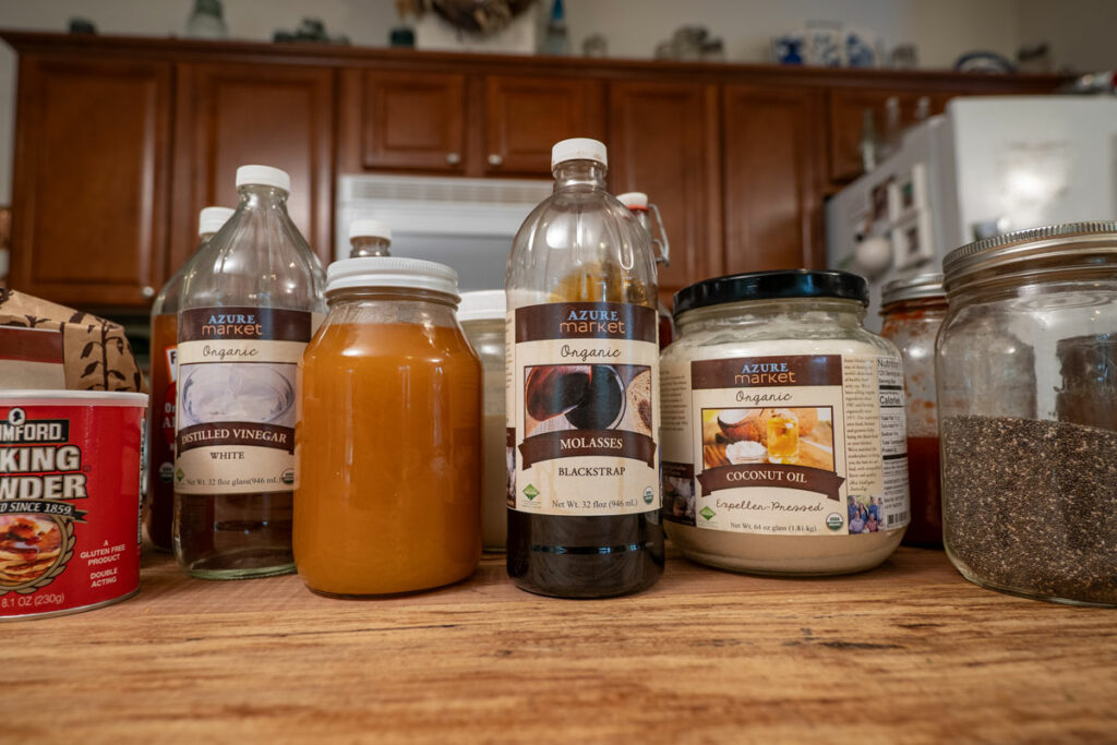 Baking ingredients in containers on a wooden kitchen island.