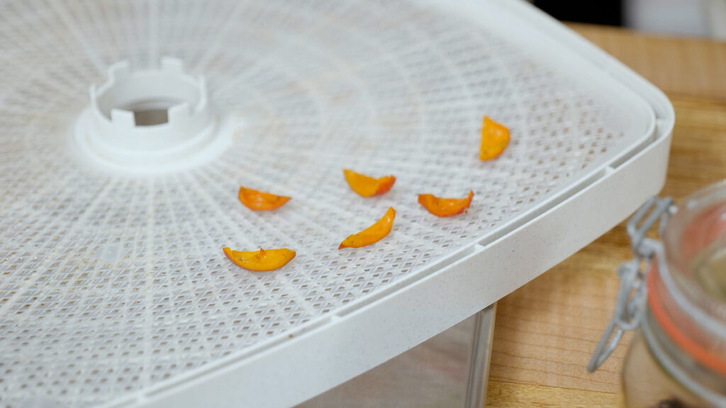 Rosehip pieces on a dehydrator tray.