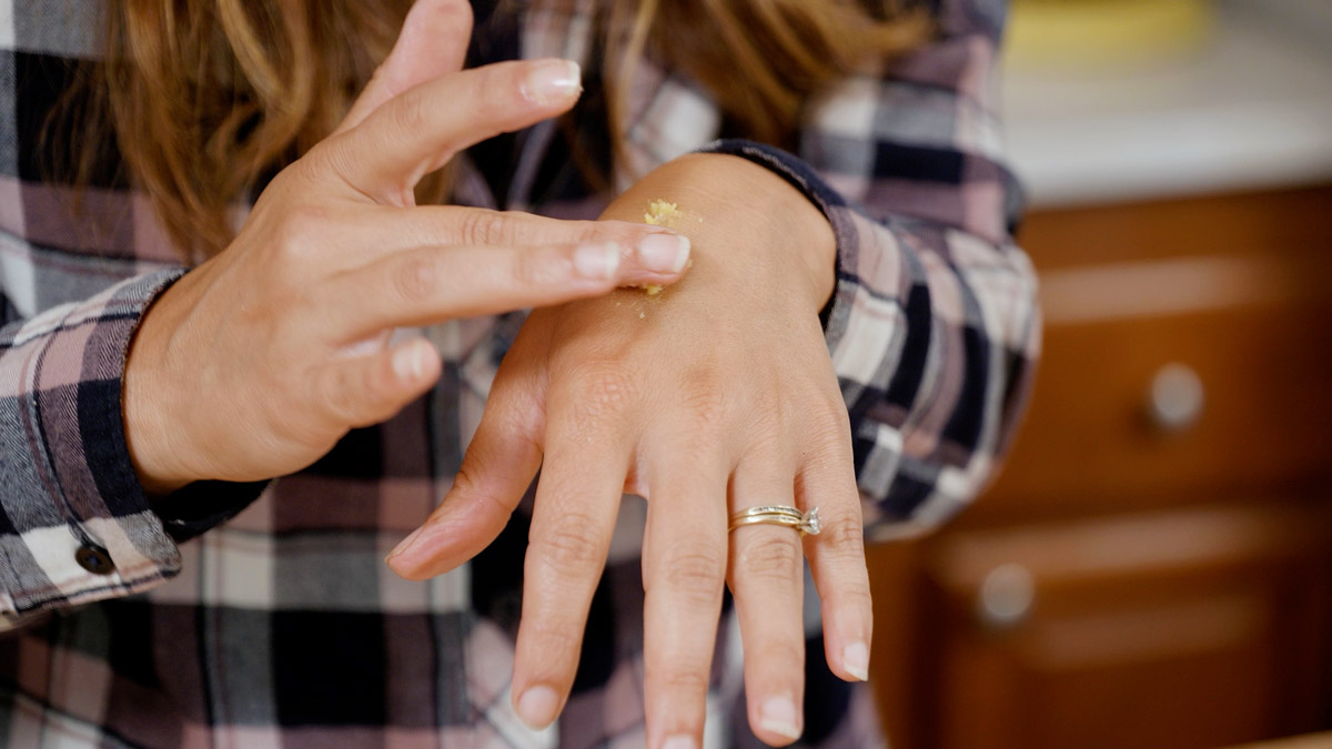 A woman rubbing healing salve onto her hand.