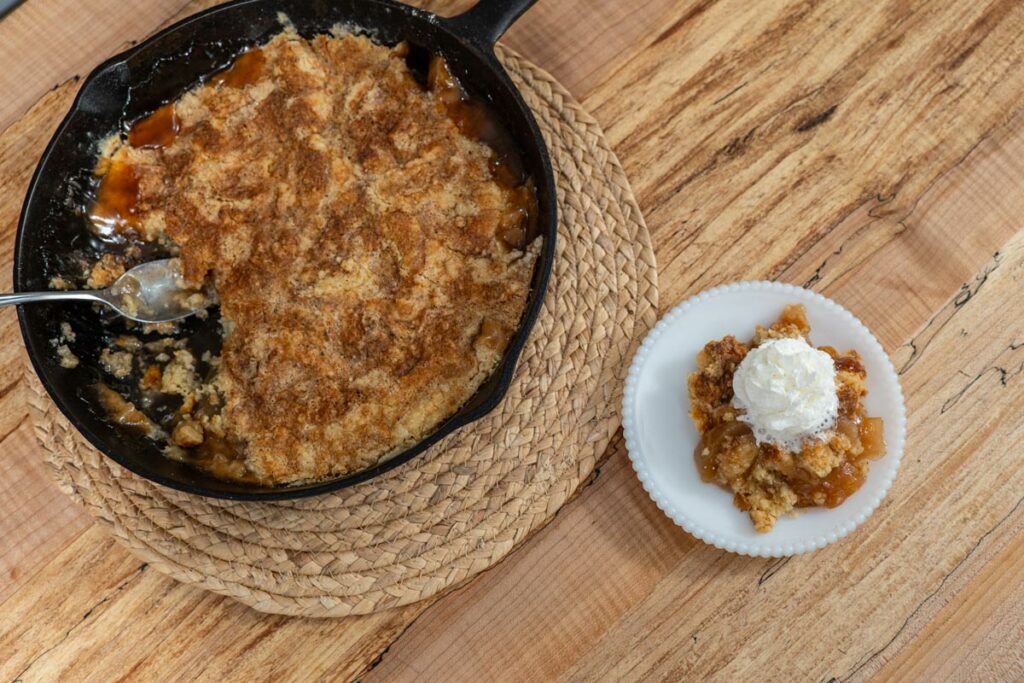 Dump cake served on a white plate with whipped cream.